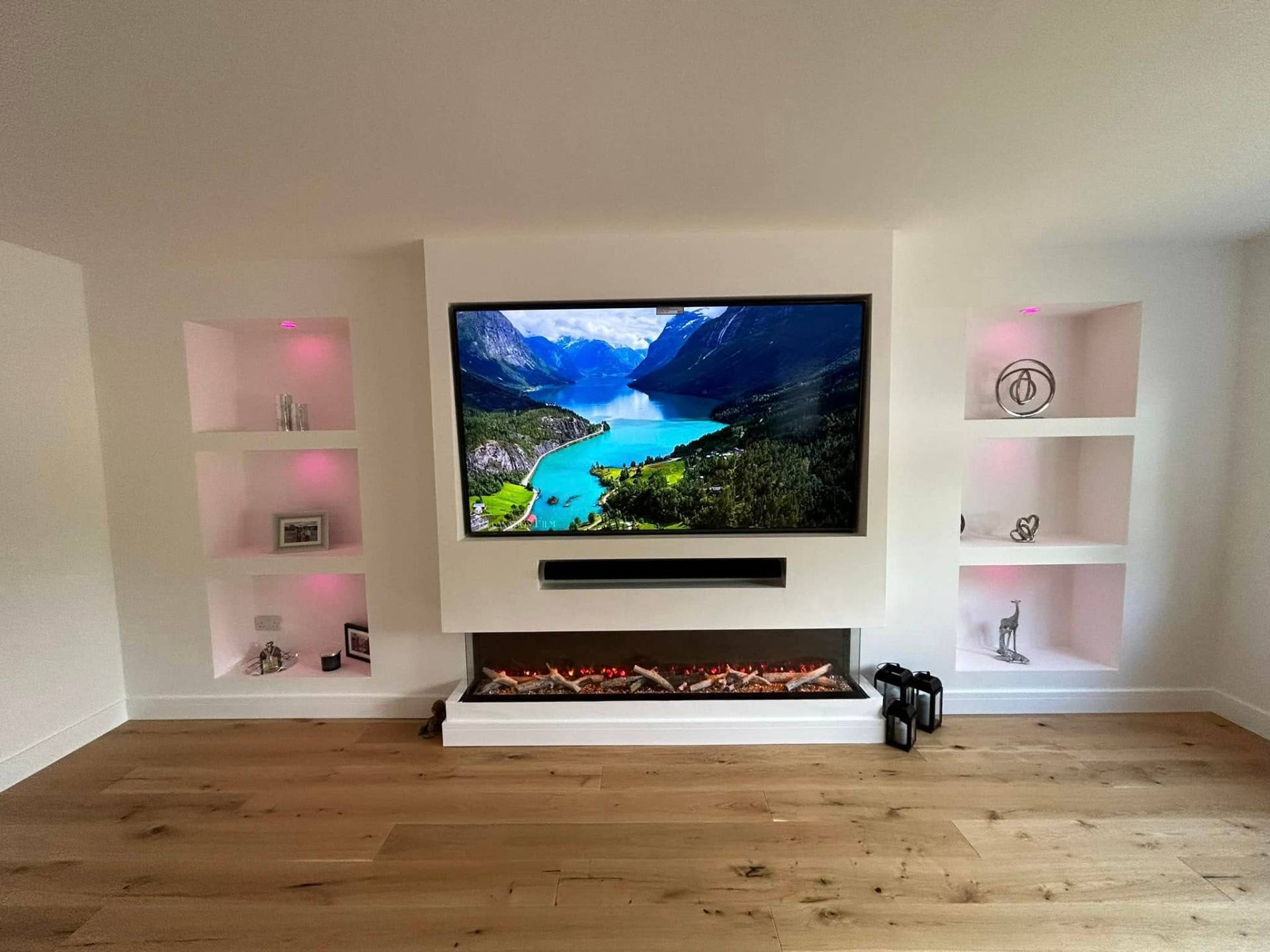 White media wall with LED-lit alcove shelving & panoramic electric fire media wall in Norfolk