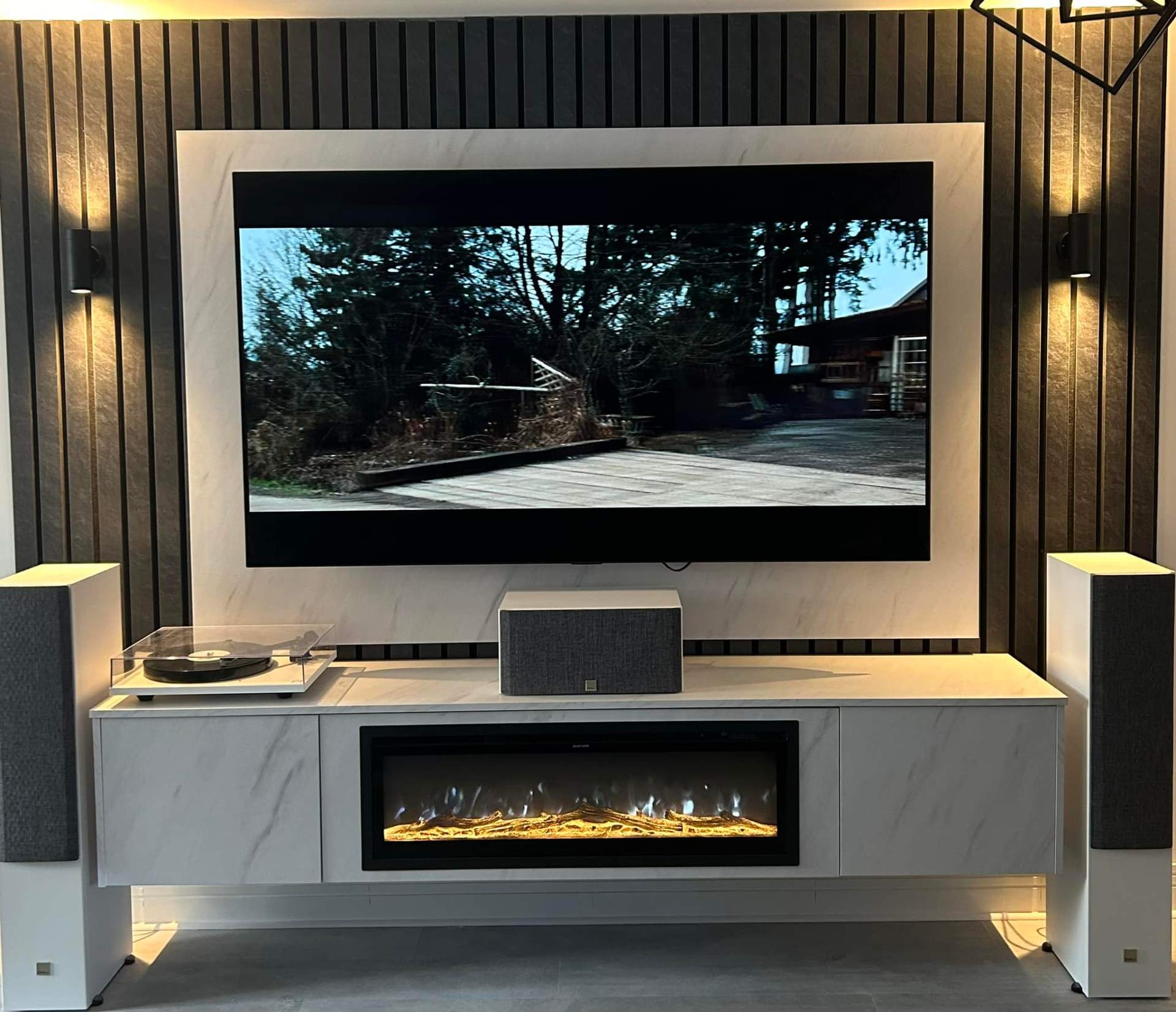 Marble-effect media wall with black slat surround, electric fire & hi-fi setup media wall in Cambridge